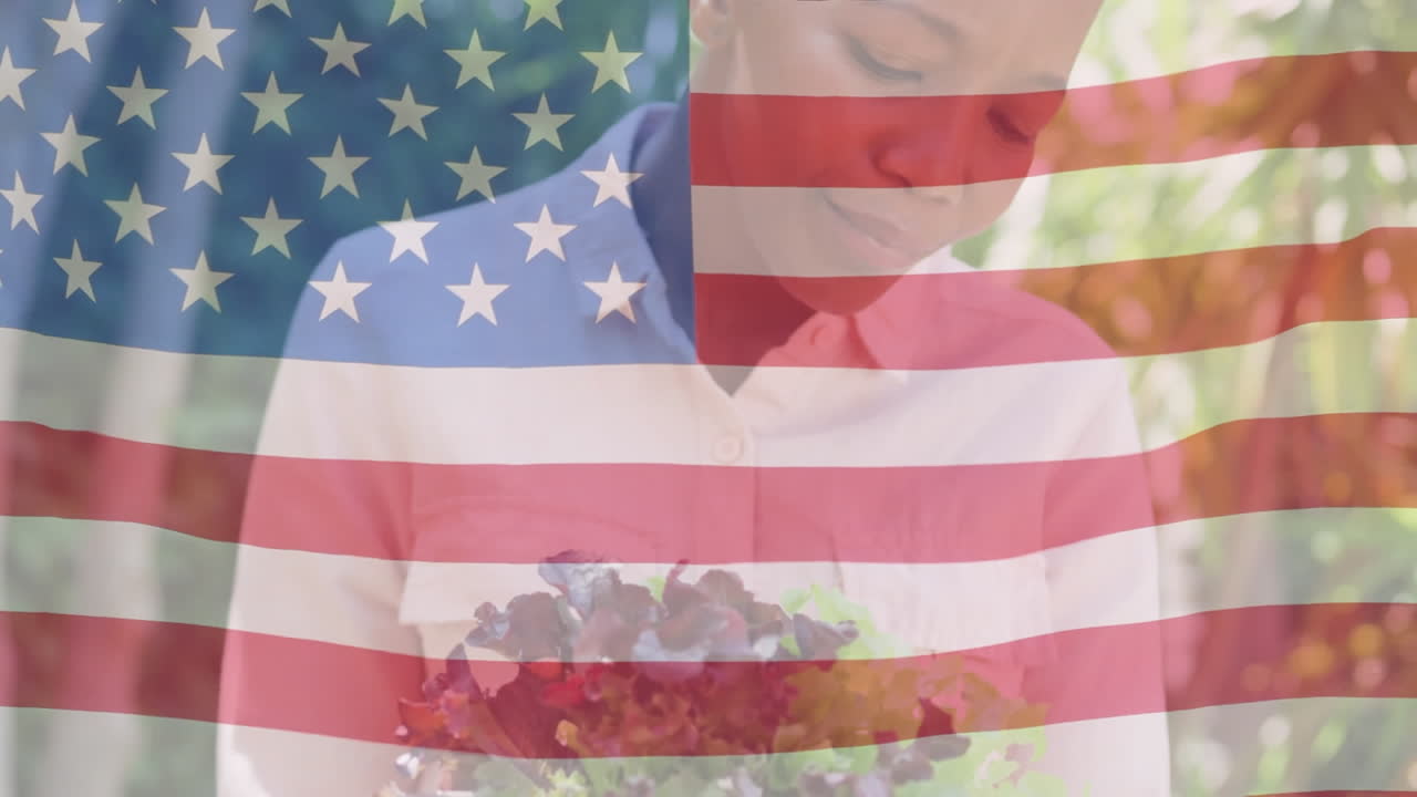 animación de la bandera de los estados unidos ondeando sobre una mujer afroamericana sonriente sosteniendo flores