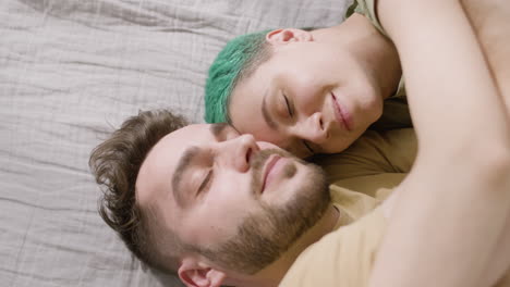 pareja feliz durmiendo cara a cara en la cama