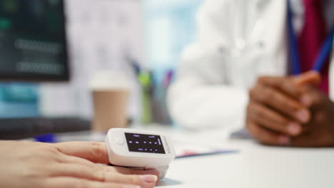médico que utiliza un oxímetro en el paciente para medir los niveles de oxígeno y la saturación