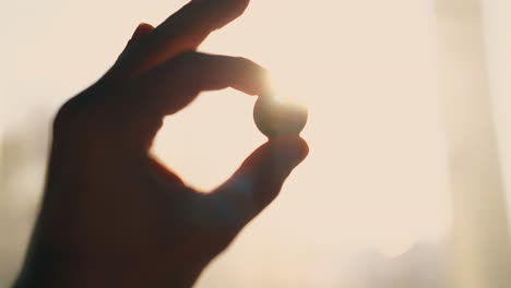 silhouette of man hand with coin at backlight close view