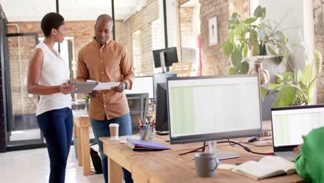 Fröhliche-Afroamerikanische-Kollegen-Nutzen-Tablet-Und-Diskutieren-über-Die-Arbeit-Im-Büro,-Zeitlupe