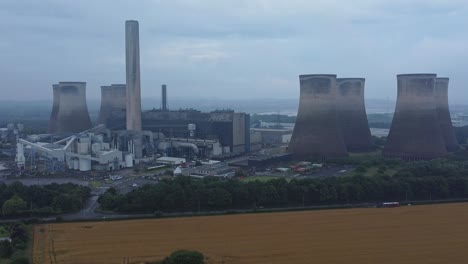 imposing concrete cooling tower power station farmland countryside aerial view slow right dolly