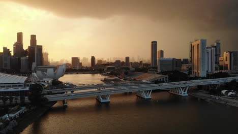 Aerial-drone-shot-of-sunset-and-thunderstorm-in-Marina-Bay,-Singapore