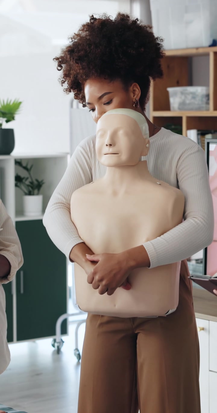 Woman Practicing CPR Technique on Medical Training Manikin
