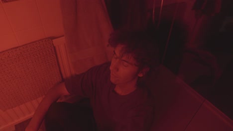 A Christian man in a bathroom, bathed in red lighting, reflects on his sin and spiritual struggle. The moody, emotional atmosphere symbolizes guilt, repentance, and introspection.