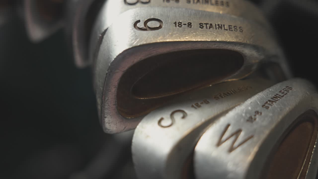 slow panning shot of a full set of irons and wedges within a golf bag