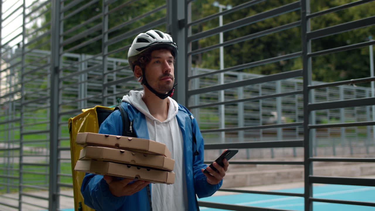 Pizza delivery man using smartphone