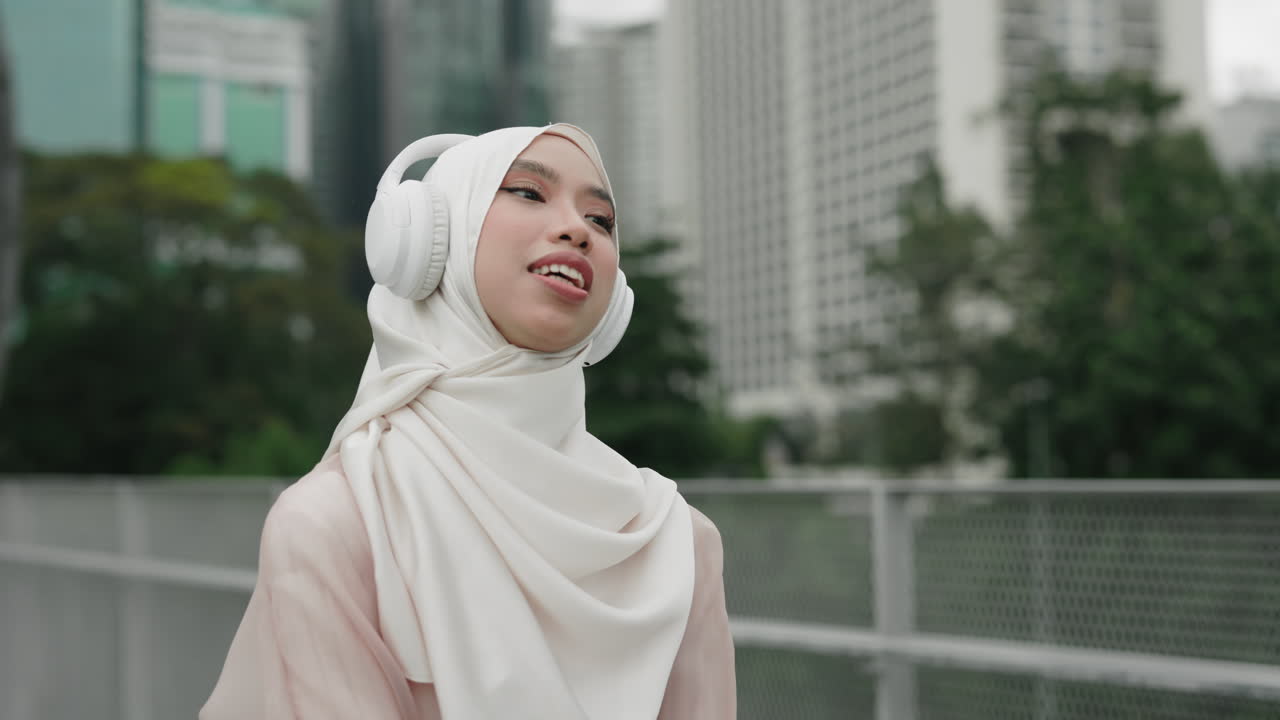 Woman in Hijab Listening to Music in the City