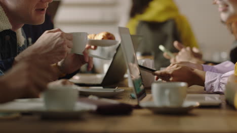 manos cerradas grupo joven de amigos bebiendo café en una cafetería disfrutando de la conversación socializando compartiendo conexión estudiantes felices charlando juntos pasando el tiempo