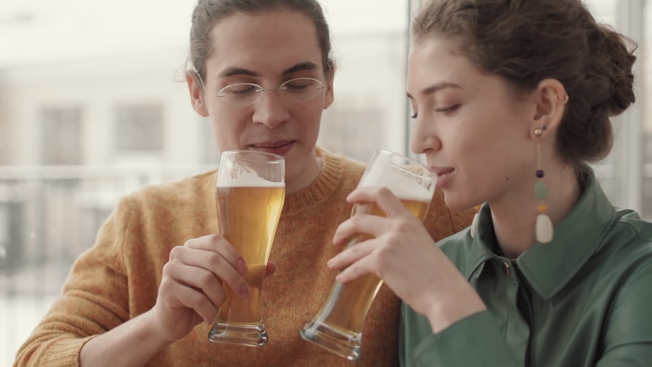 hombre y mujer bebiendo cerveza en un café