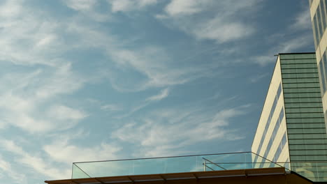 Wolkenfetzen-Am-Blauen-Himmel-über-Der-Ecke-Eines-Modernen-Bürogebäudes