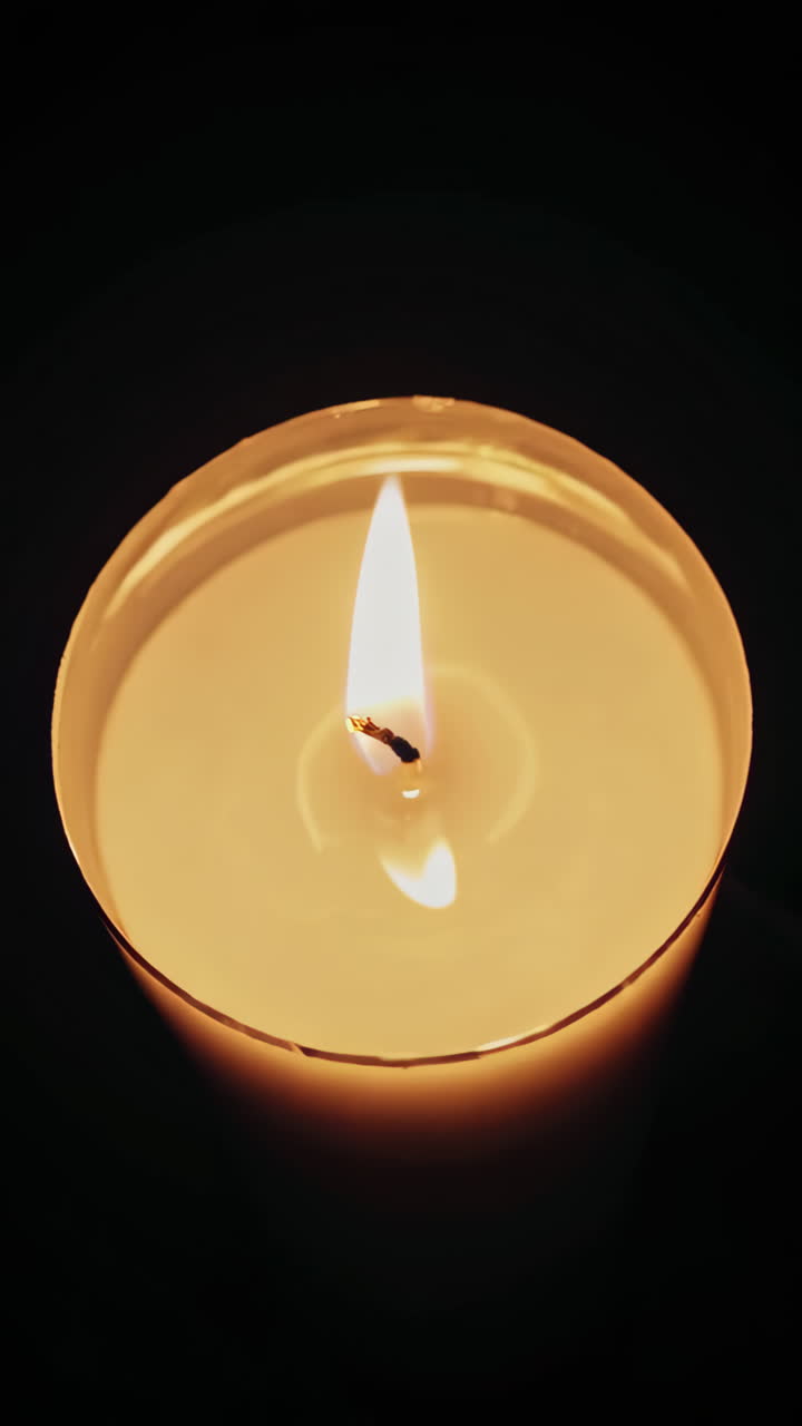 Un primo piano della fiamma di una candela al buio