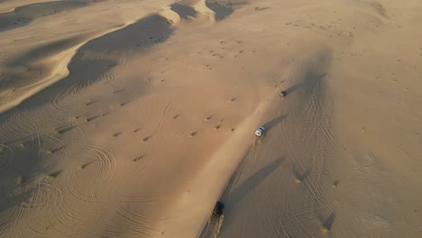 4K:-Drone-tracking-the-group-of-4x4-during-the-desert-safari-in-the-Al-Qudra-desert-of-Dubai,-United-Arab-Emirates