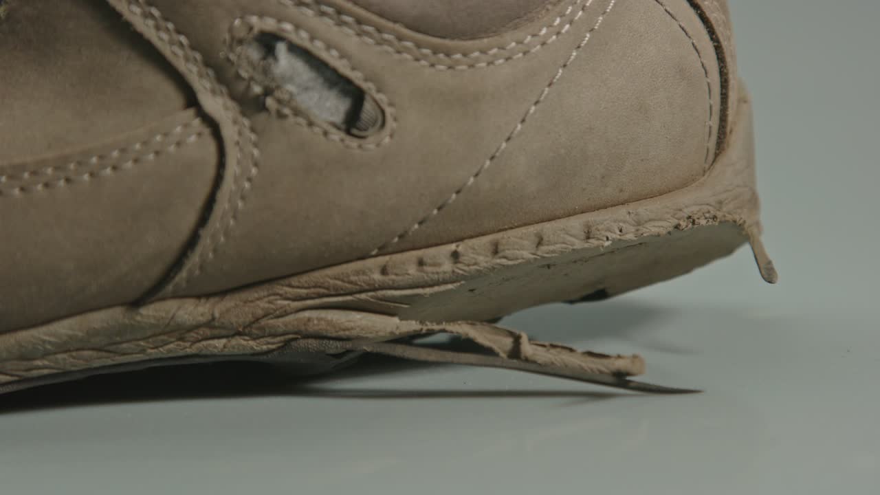 muñeca de agujeros en el talón de una bota de senderismo desgastada