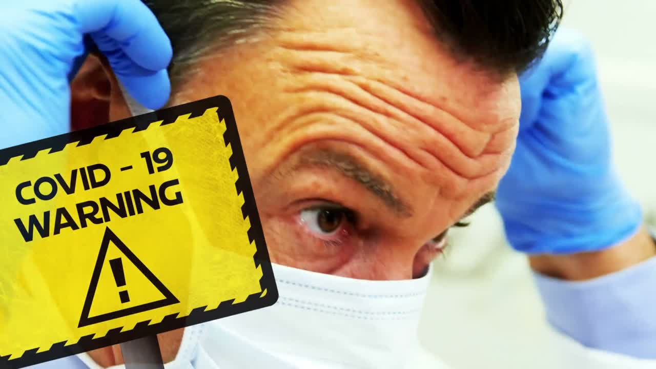 백그라운드에 의료 종사자가 있는 코로나19 경고 단어의 애니메이션