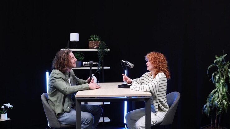 Two Young Adults Greet and Sit for a Podcast Interview