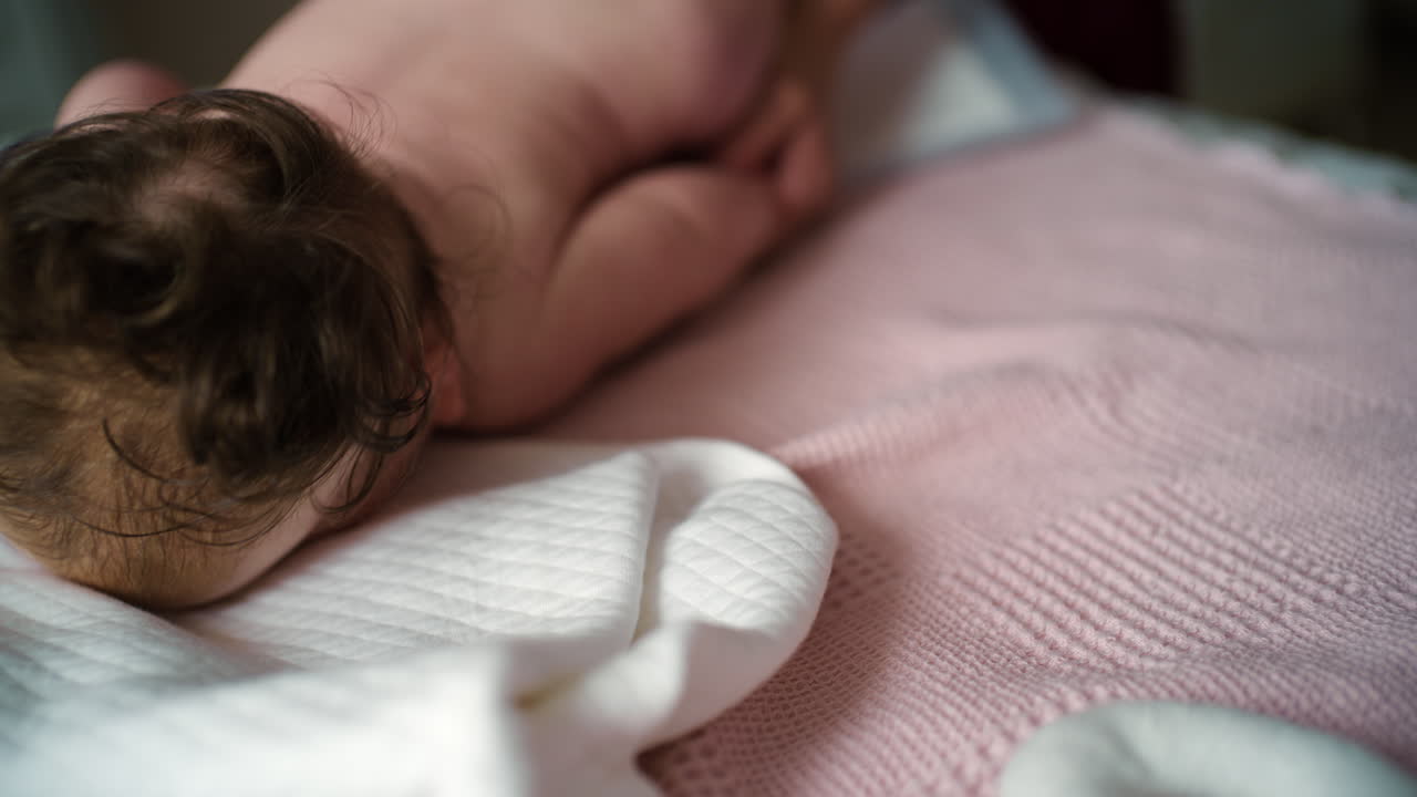 Bambino sdraiato sulla schiena mentre un adulto lo massaggia ed esegue esercizi di mobilità.