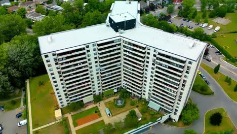 white y-building condo summer day surrounded by luxury homes green forests calm day drone flyover overlooking quiet nobody outside yuld1-3