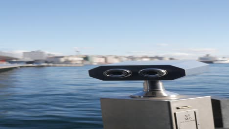 binoculars overlooking a harbor with a cityscape in the background