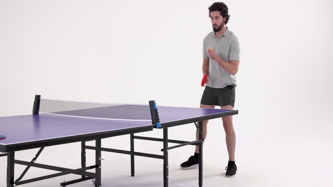 Playing table tennis, man holding paddle and preparing to hit ball