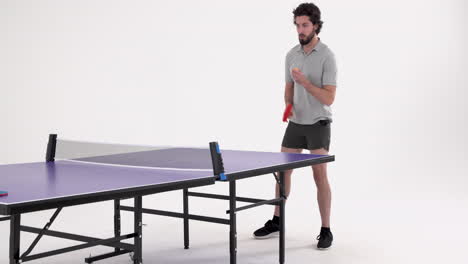 playing table tennis, man holding paddle and preparing to hit ball