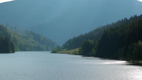 zoom in the level of the sance drinking water reservoir with a natural valley full of hills and mountains around the water level which moves in a strong wind