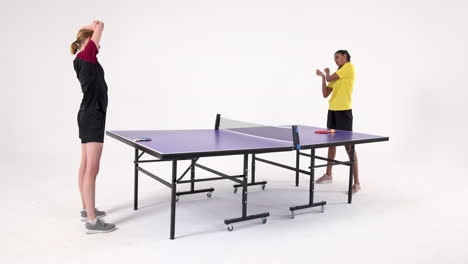stretching before playing table tennis, two women standing by table tennis table