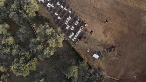 aerial shot of forest parked cars and chairs at ground waiting people to sit on , preparation before music festival pelion magnisia greece