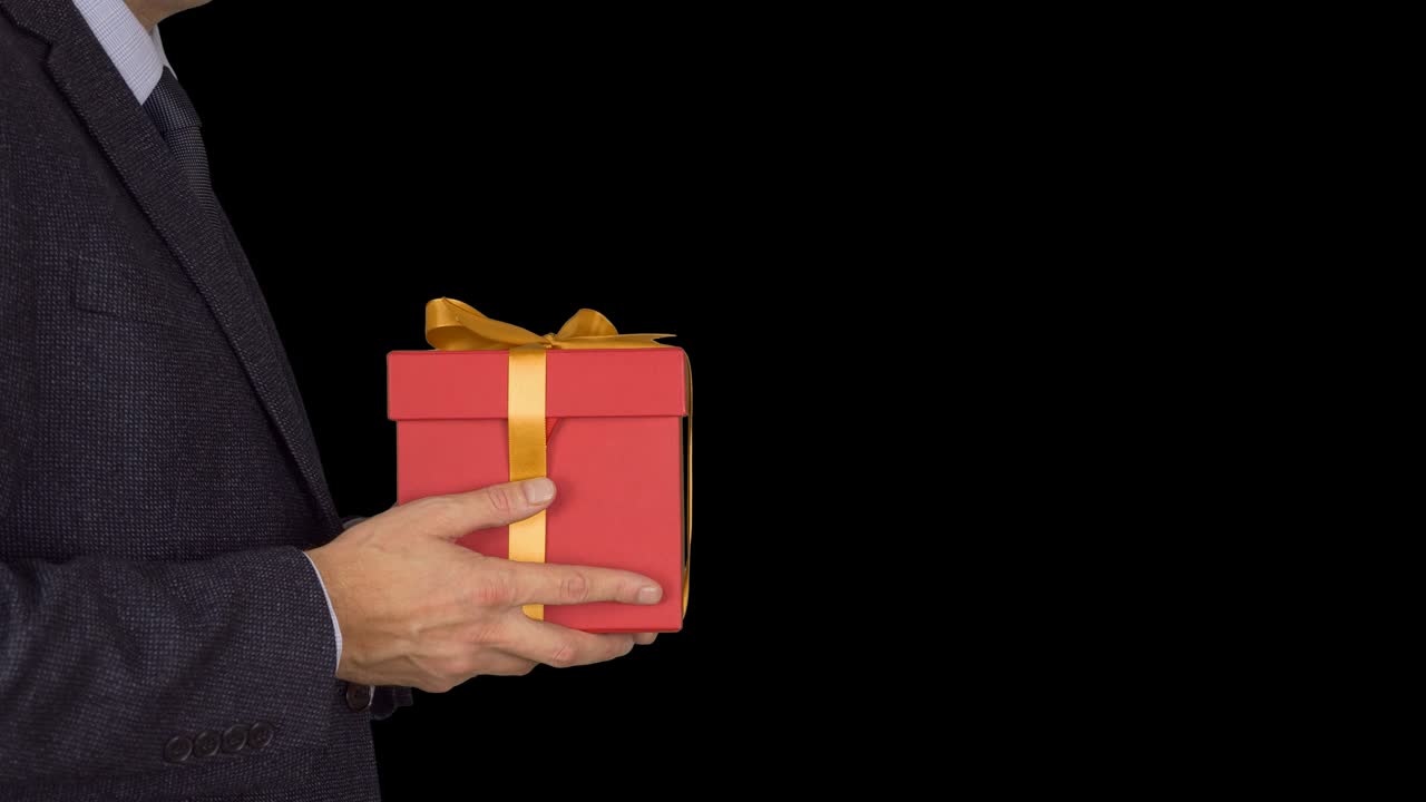 카우카스 사업가 은 선물 상자를 들고 주세요. 초점을 맞추지 않는 것에서 초점을 맞춘 움직임으로. 클래식 비즈니스 슈트를 입은 성인 남자가 빨간 선물 상자 들고. 알파 채널 크로마 키 투명한 배경.