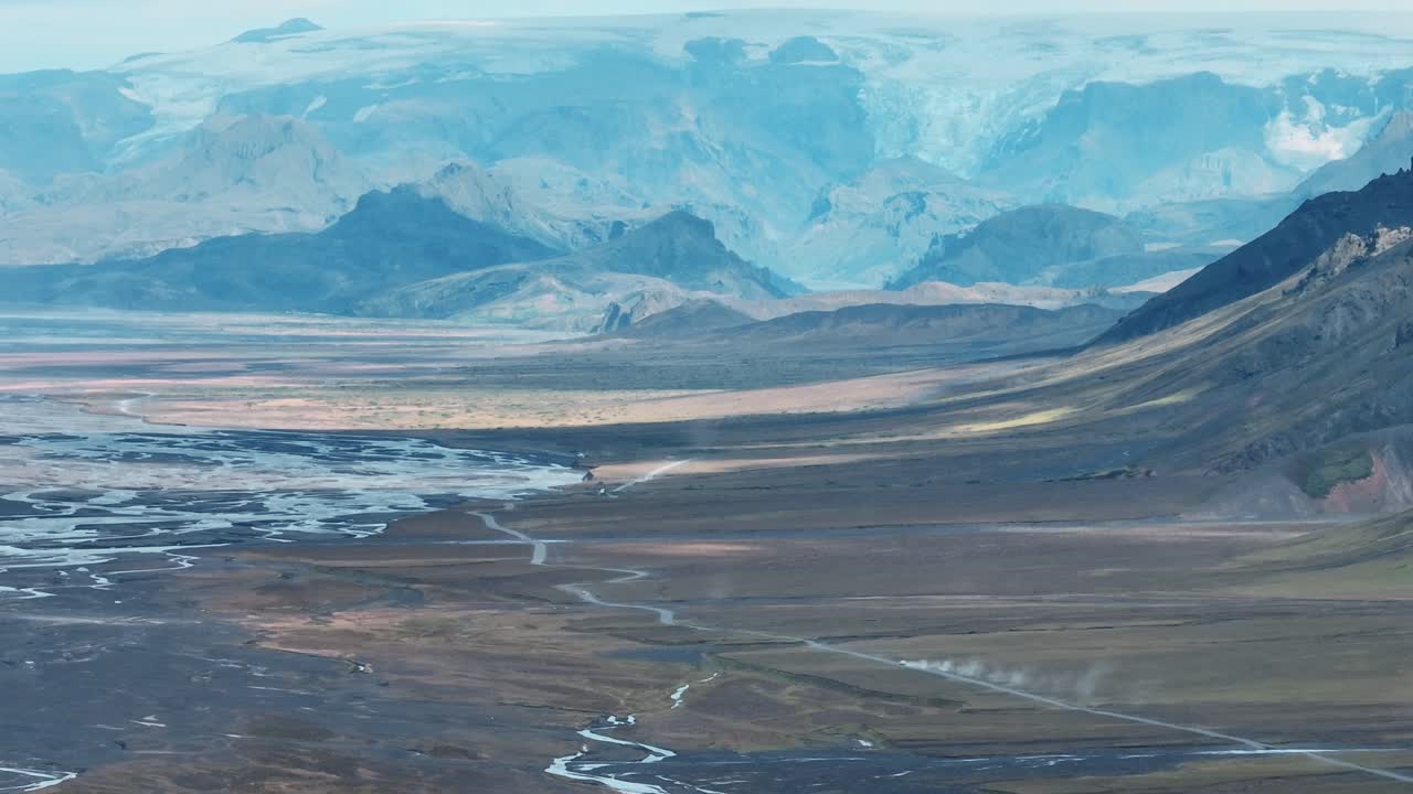 Naturskøn udsigt over en bil der kører mod højlandet i Sydisland.