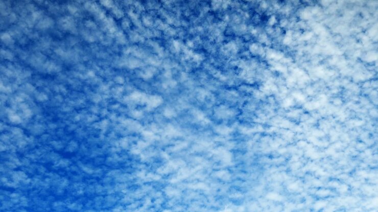 Time lapse clip of white fluffy clouds over blue sky
