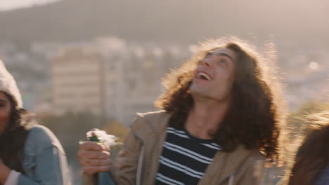 happy group of friends celebrating on rooftop making toast drinking alcohol having fun together enjoying celebrating summer vacation at sunset