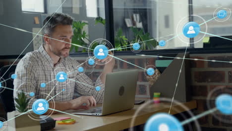 animation of network of connections with icons over caucasian businessman using laptop in office