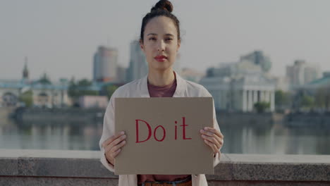 woman holding a sign saying "do it"