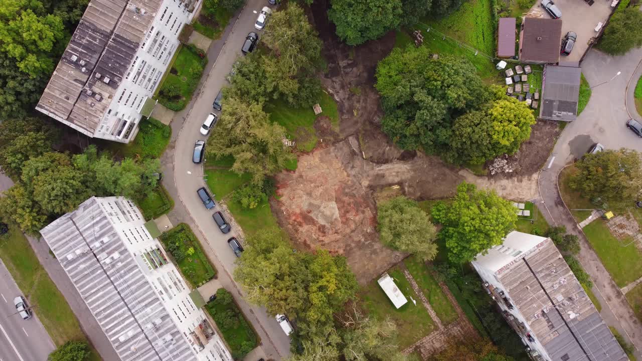 Aerial view of construction site within residential neighborhood surrounded by trees