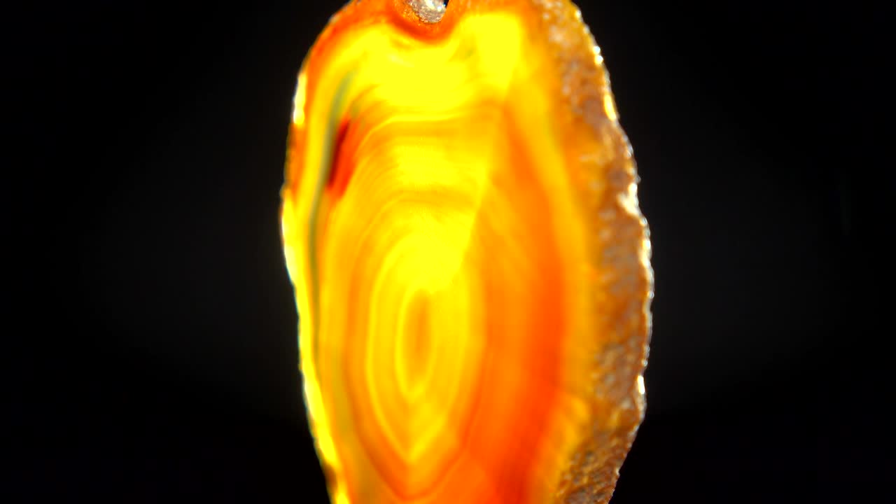 Seamlessly rotating an orange mineral (Orange Agate) in front of black background