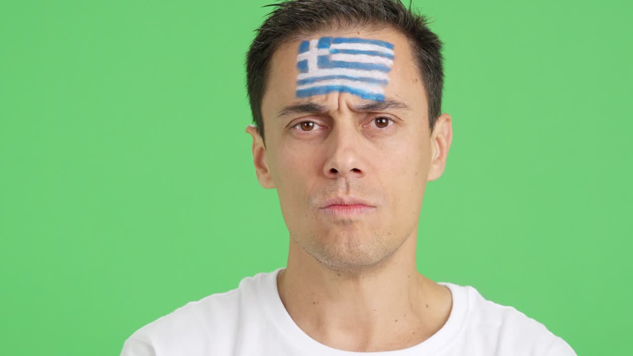 Serious man with a greek flag painted on the face