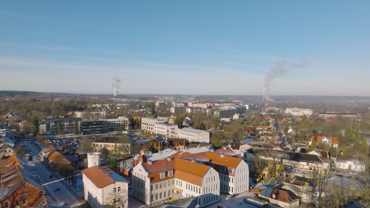 vista aérea del casco antiguo de kuldiga, casas con tejas rojas, torre de telecomunicaciones, día soleado de invierno, destino de viaje, amplia toma de drone moviéndose hacia atrás
