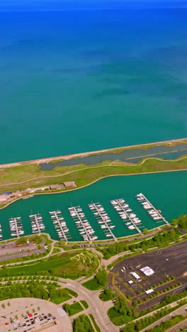 Eye-catching site of the terrific Lake Michigan waterfront. Green park zones and yacht club at the backdrop of turquoise waters. Vertical video