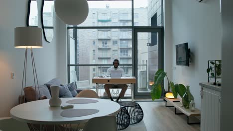 hombre trabajando desde casa en un apartamento moderno