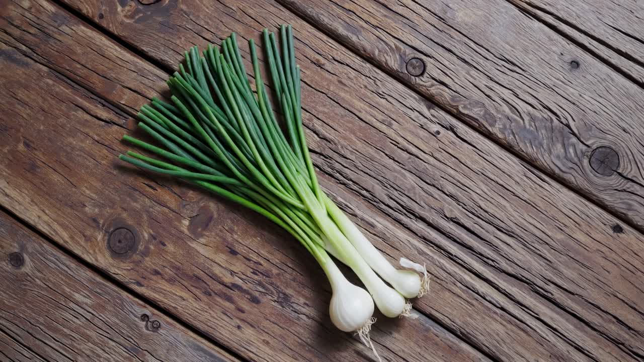 Visão de cima para baixo de cebolas verdes frescas em tábuas de madeira rústicas. O vídeo captura as cores vibrantes.