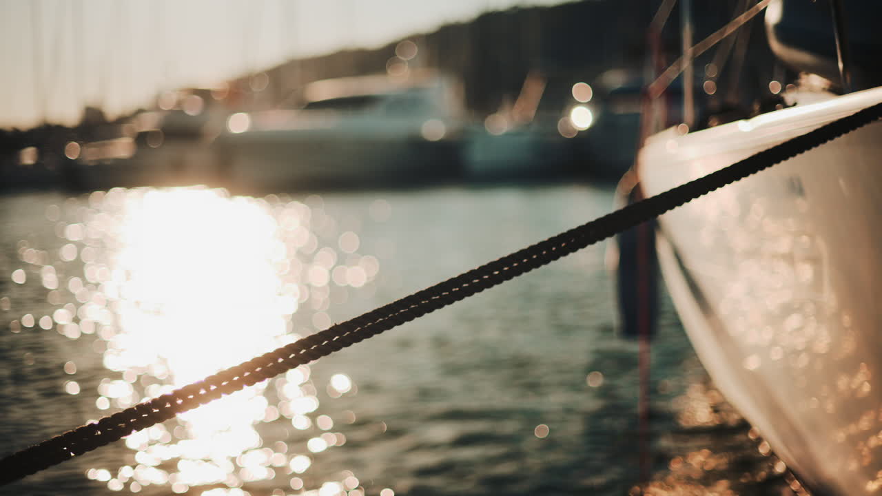 Golden sunlight shimmering on the side of a yacht floating on calm water