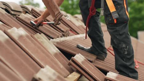 static close up of specialist worker preparing tiles of house roof for solar panel installation