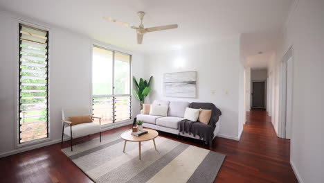 apartment modern interior lounegroom with grey striped carpet rug ocean abstract painting and ornamental tropical plant