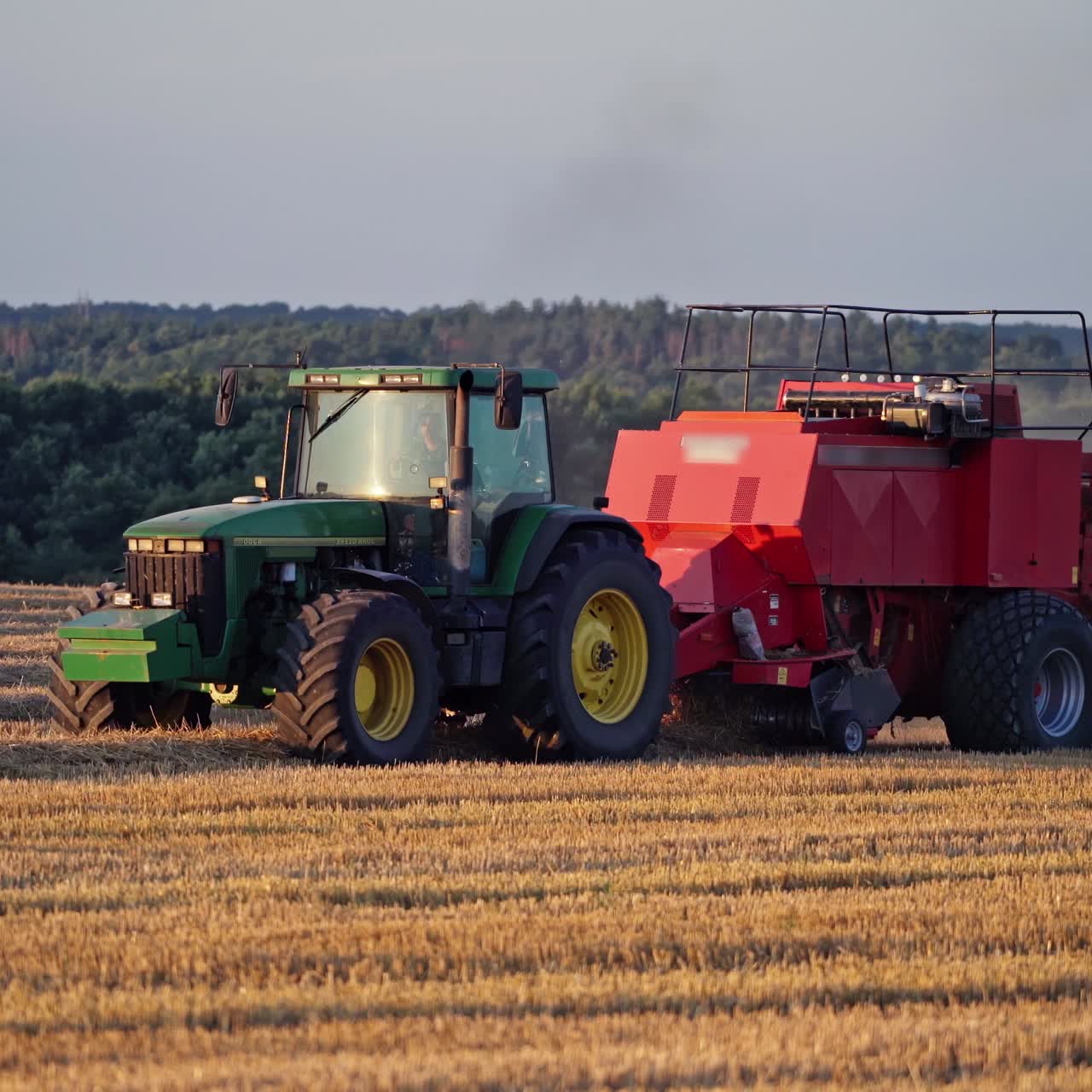 Tractor with bales of hay on trailer