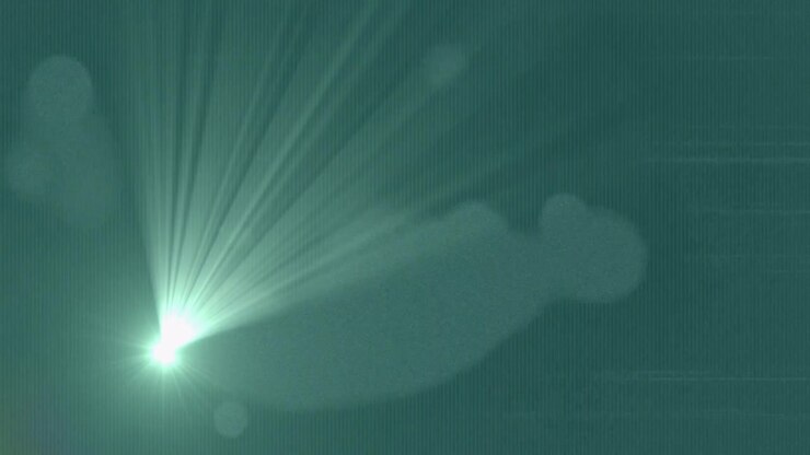 Bright spot appearing, flare growing and fanning rays, sweeping right, fading, showing teal texture