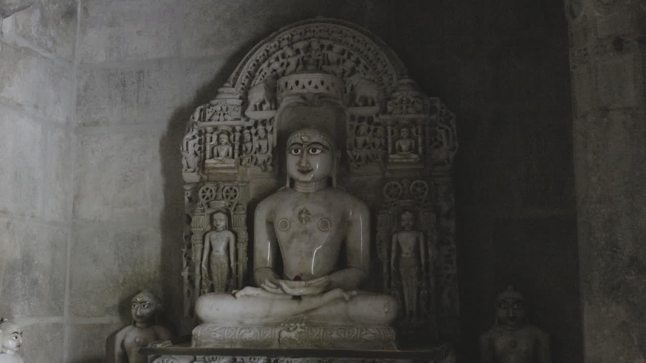 la estatua del dios santo jainista en el templo jainista desde un ángulo plano el video se tomó en el templo jain de ranakpur, rajasthan, india