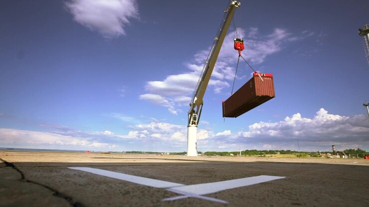 Industrial crane lifting a shipping container at the port.