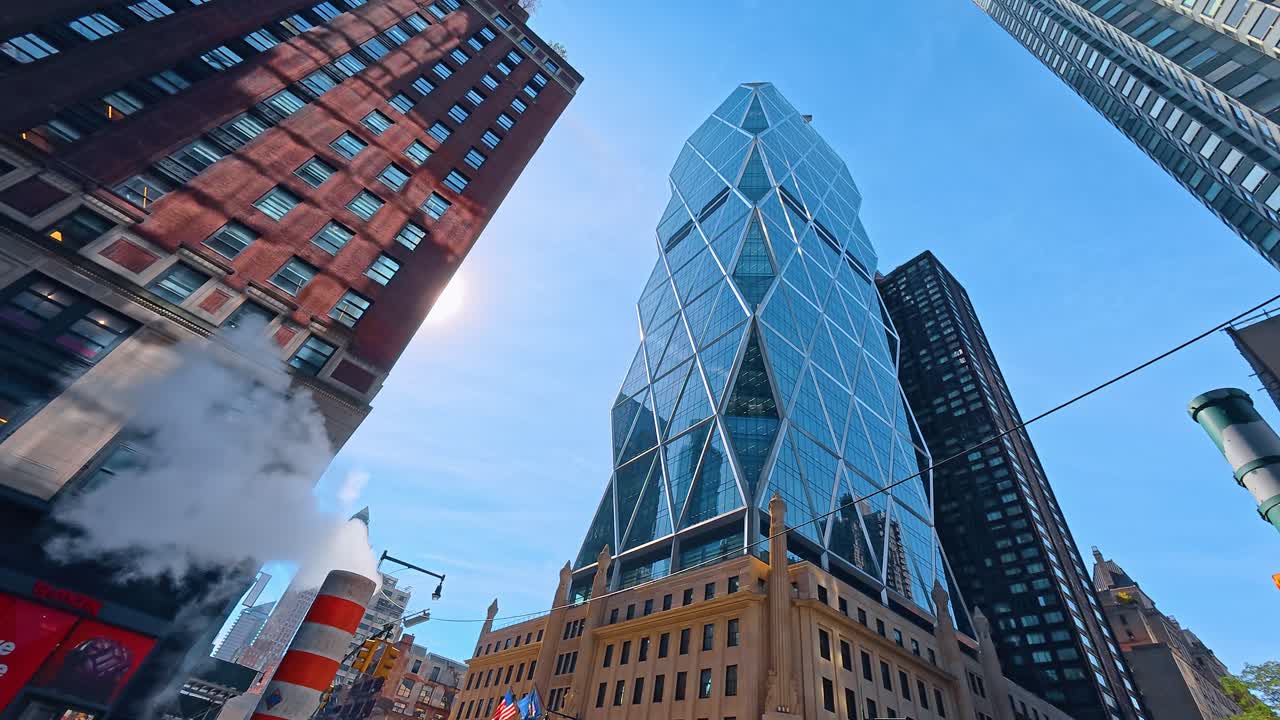 Nova York, EUA, 9 de agosto de 2025: Cano de vapor em uma rua da cidade perto de arranha-céus modernos. Paisagem urbana com chaminé utilitária listrada com vapor e arquitetura em grade diagonal em Manhattan