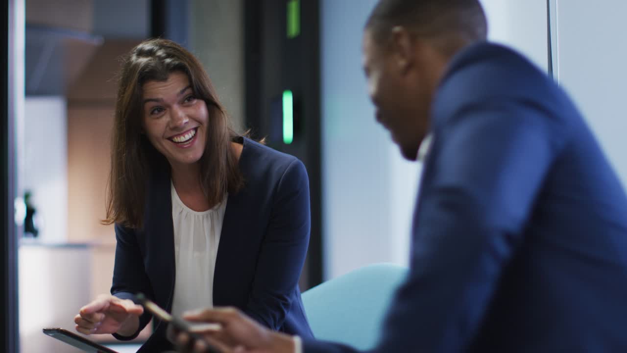 hombre de negocios y mujer de negocios sonrientes hablando en una oficina moderna